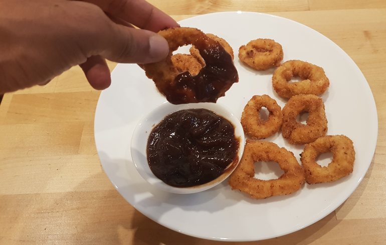 Cooked chicken ring dipped into sauce